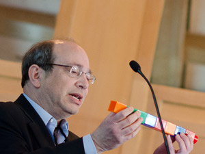 Нил Аронин использует гигантские блоки Lego, чтобы объяснить, как препараты для подавления генов могут распадаться на более мелкие молекулы с собственными побочными эффектами. Изображение предоставлено: Лев Блюменштейн для CHDI